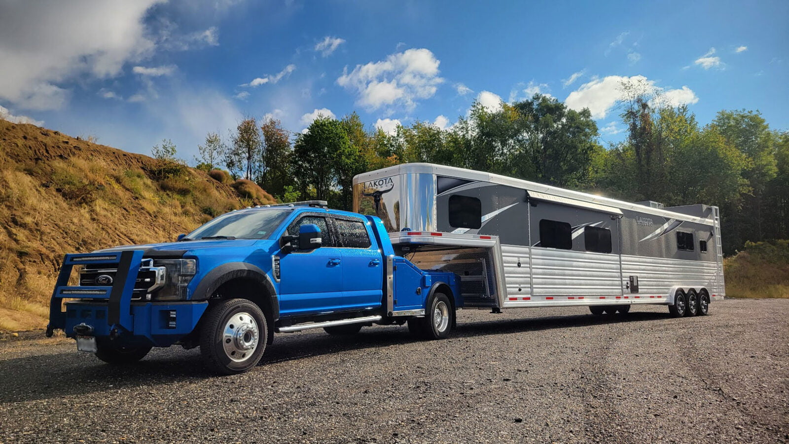 A Ford F-550, configured as a fifth wheel hauler truck, efficiently towing a gooseneck horse trailer, demonstrating its versatility and power in hauling capabilities.