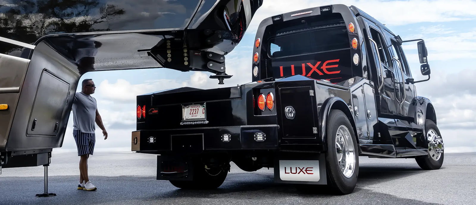 A Freightliner M2 106, designed as a fifth wheel RV hauler truck, is towing a luxury fifth wheel made by their partner company Luxe Fifth Wheel.