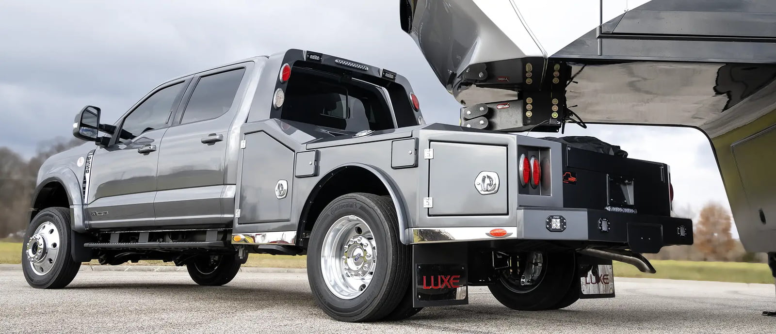 A Luxe Trucks Ford F-550, designed as a fifth wheel RV hauler truck, is towing a luxury fifth wheel made by their partner company Luxe Fifth Wheel.