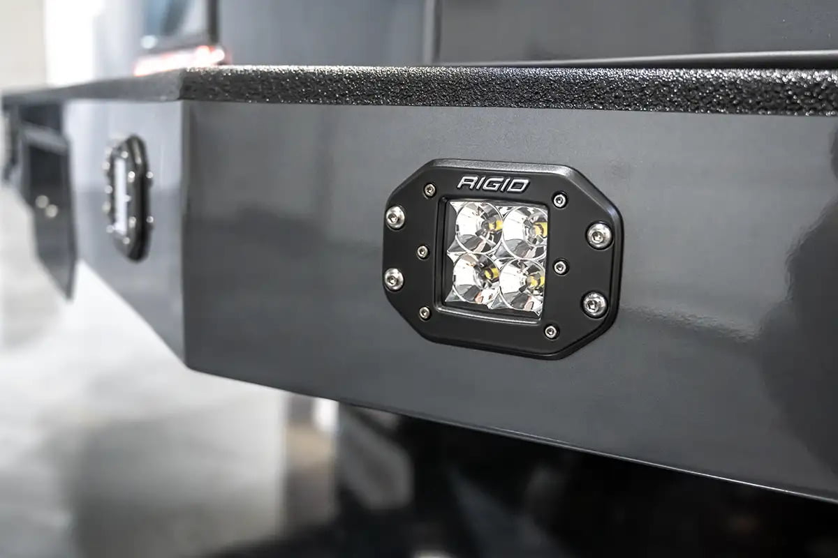Close-up of Rigid lights on the painted smooth aluminum bumper of a Luxe Truck, underlining the durability and functionality crucial for a fifth wheel hauler truck.