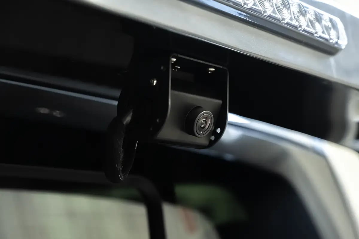 Close-up view of a rear back-up camera on a Luxe Truck's light pylon, an essential safety enhancement for a hauler truck.